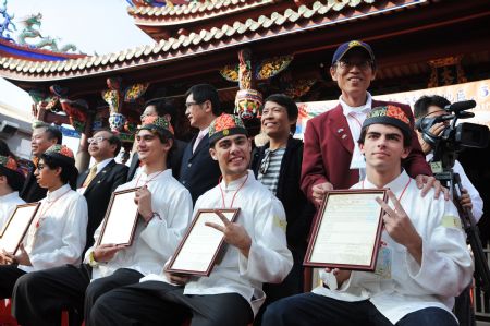Parents and students pose for group photo after completing the adult ceremony held in the Confucius Temple of Taipei, southeast China&apos;s Taiwan, Dec. 6, 2009. A total of 130 students took part in the Chinese traditional adult ceremony in Taipei on Sunday. [Wu Ching/Xinhua]