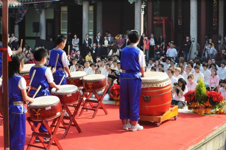 Pupils perform beating drum at the adult ceremony held in the Confucius Temple of Taipei, southeast China&apos;s Taiwan, Dec. 6, 2009. A total of 130 students took part in the Chinese traditional adult ceremony in Taipei on Sunday. [Wu Ching/Xinhua]