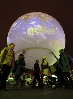 People walk on the street with a huge globe in the background in Copenhagen December 6, 2009. Copenhagen is the host city for the United Nations Climate Change Conference 2009, which lasts from December 7 until December 18.(Xinhua/Reuters Photo)