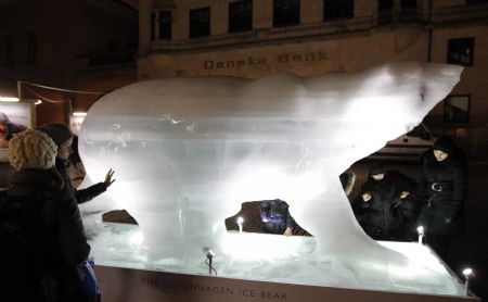 A woman touches an ice sculpture of a polar bear in downtown Copenhagen December 6, 2009. Copenhagen is the host city for the United Nations Climate Change Conference 2009, which lasts from December 7 until December 18.(Xinhua/Reuters Photo)