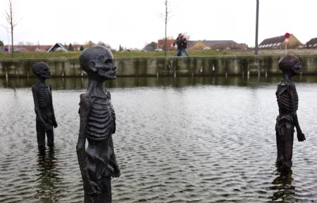 The picture taken on Dec. 8, 2009, shows models of supposed refugees come into being by climate change erected in water outside the conference center of the 3rd Annual Climate Change Summit in Copenhagen, Demark. UN&apos;s climate panel expects 200 million climate refugees before 2050. [Xie Xiudong/Xinhua]