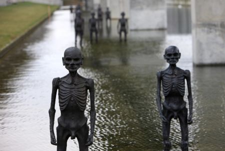 The picture taken on Dec. 8, 2009, shows models of supposed refugees come into being by climate change erected in water outside the conference center of the 3rd Annual Climate Change Summit in Copenhagen, Demark. UN&apos;s climate panel expects 200 million climate refugees before 2050. [Xie Xiudong/Xinhua]