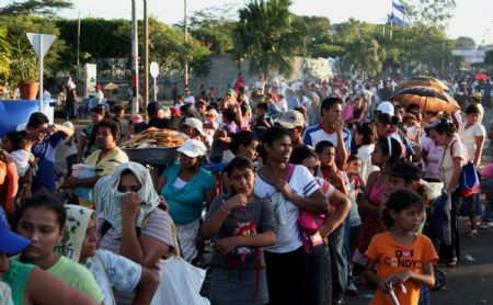 Local citizens queue up to get free food in Managua, capital of Nicaragua, Dec. 7, 2009.[Xinhua]