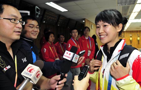 Yi Siling(R) of China is interviewed after the women&apos;s final of the 10m Air Rifle in the 2009 East Asian Games at South China Athletic Association in Hong Kong on Dec. 8, 2009. Yi won the silver with 500.7 rings in total.[Xinhua]