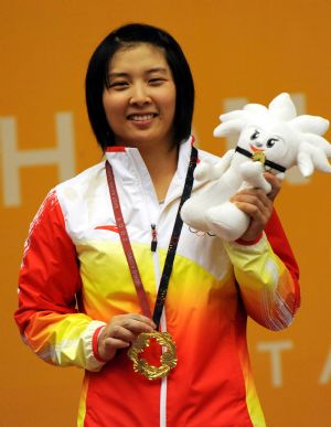 Li Ping of China greets the spectators during the awarding ceremony for the women&apos;s final of 53kg category in weightlifting in the 2009 East Asian Games at Lai Chi Kok Pard Sport Centre in Hong Kong on Dec. 8, 2009. Li Ping won the title with 215kg in total (93kg in snatch, 122kg in clean and jerk).[Xinhua]