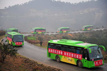 Vehicles carrying resettlers drive on the hills in Junxian County, Danjiangkou City of central China&apos;s Hubei Province December 8, 2009. More than 760 residents in central China began to move from their mountainous hometown in Junxian County in the Danjiangkou Reservoir area to the Denglin Farm in Yicheng City 300 km away on Tuesday, making way for the giant south-to-north water diversion project.[Xinhua] 