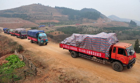 Vehicles carrying resettlers drive on the hills in Junxian County, Danjiangkou City of central China&apos;s Hubei Province December 8, 2009. [Xinhua]