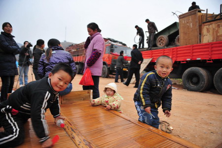 Two children play on the bamboo bed to be loaded in Junxian County, Danjiangkou City of central China&apos;s Hubei Province December 8, 2009.[Xinhua]