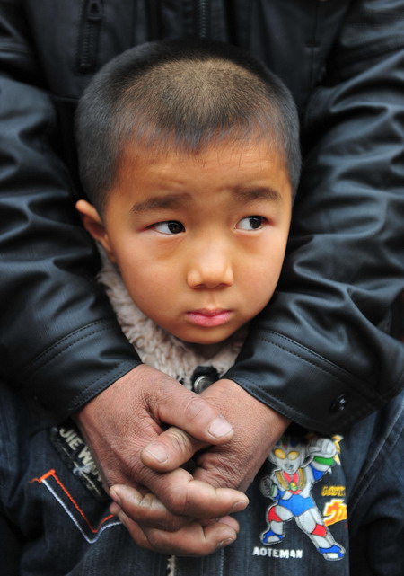 A boy armed by his father looks at his new home in Yicheng City, 300 km away from his former hometown, in the fertile valley formed by the Yangtze&apos;s tributary Hanjiang River December 8, 2009.[Xinhua]