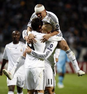 Real Madrid's Cristiano Ronaldo (L) reacts with team mates Pepe (top) and Karim Benzema (R) after scoring against Olympique Marseille during their Champions League soccer match at the Velodrome stadium in Marseille December 8, 2009.