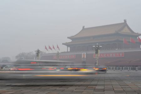 Vehicles pass by the Tiananmen Square in a foggy day in Beijing, Dec. 10, 2009. A heavy fog cloaked the city of Beijing Thursday. [Yin Dongxun/Xinhua]