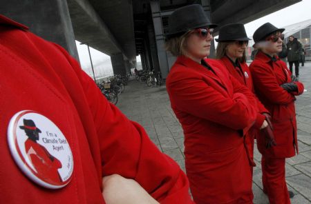 Members of environmental activist group Act!onaid, dressed as &apos;climate debt agents&apos;, stand outside the congress centre, before the opening of the United Nations Climate Change Conference 2009 in Copenhagen December 7, 2009. [Xinhua/Reuters]