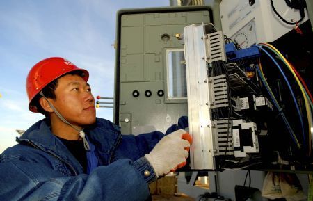 An electrician conducts on spot technical inspection and debugging to the apparatus of the 330 kilovoltage booster substation, at the Jiuquan Dongfeng Electricity Generation Field, in Guazhou County of Jiuquan City, northwest China&apos;s Gansu Province, Dec. 8, 2009.[Zhu Shiliang/Xinhua]