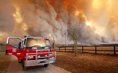 A firetruck is seen as a bushfire approaches the town of Labertouche, 90km (56 miles) east of Melbourne, February 7, 2009. Aircraft dropped water bombs on raging Australian bush fires and homes went up in flames on Saturday as a once-in-a-century heatwave sent temperatures in Melbourne to their highest on record. Australian bush fires killed 14 people in the southern state of Victoria on Saturday, police and local media said.