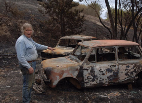  A man points to his damaged car while talking about the bushfire disaster on a farm, 50km to the north of Melbourne, Victoria state, Australia, Feb. 11, 2009. Fire continued to ravage across southern Australia Tuesday, threatening local communities and killing at least 181 so far. More than 900 homes were destroyed in the blaze, making it the country's worst bushfire disaster in history. (Xinhua/Jiang Yaping)
