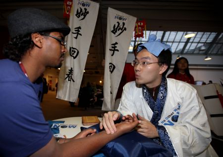 A member of China Youth Delegation who represents a Chinese doctor feels the pulse of an attendee during an activity promoting environmental protection, at Bella Center, the venue of the United Nations Climate Change Conference, in Copenhagen, Denmark, Dec. 9, 2009. 