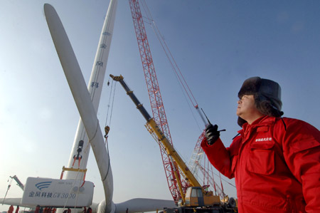 A worker instructs the installation of a huge wind turbine in Dabancheng of northwest China&apos;s Xinjiang Uygur Autonomous Region Dec. 10, 2009. [Wang Fei/Xinhua]