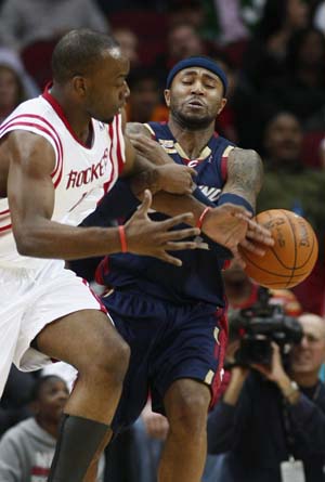 Houston Rockets forward Carl Landry (L) and Cleveland Cavaliers guard Mo Williams wrestle for a loose ball in the first half of their NBA basketball game in Houston December 9, 2009. Rockets wins with 95-85.[Xinhua/Reuters]