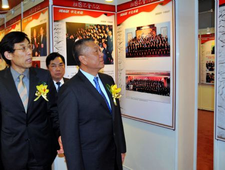 Edmund Ho Hau Wah (R), chief executive of Macao Special Administrative Region, visits a photo exhibition marking the 10th anniversary of Macao&apos;s return to China, in Macao, south China, Dec. 10, 2009. [Zhang Jiawei/Xinhua] 