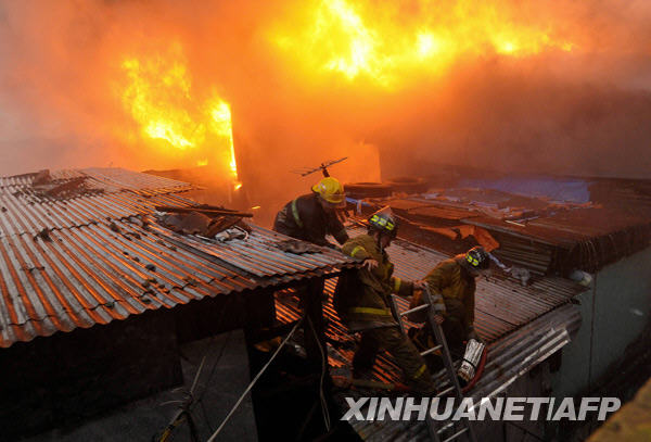 Firemen try to put out fire in the heart of Metro Manila, capital of the Philippines, Dec. 10, 2009. Local reports said that at least two people were killed in the fire. [Jon Fabrigar/Xinhua]