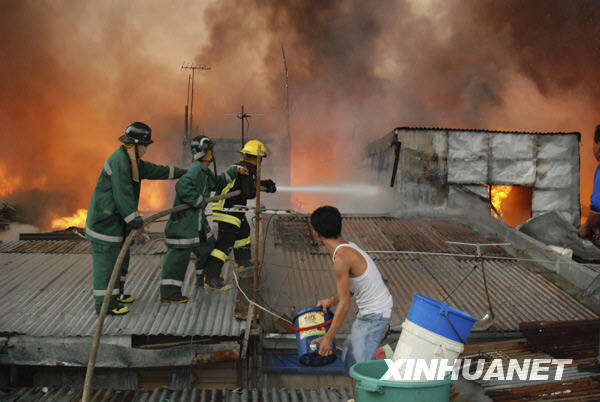 Firemen try to put out fire in the heart of Metro Manila, capital of the Philippines, Dec. 10, 2009. Local reports said that at least two people were killed in the fire. [Jon Fabrigar/Xinhua] 