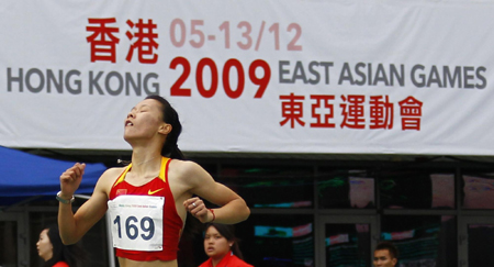 China&apos;s Li Yanfei holds a Chinese flag after she won the women&apos;s 20 km walk final at the East Asian Games in Hong Kong December 10, 2009. [China Daily/Agencies] 