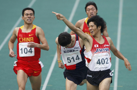 Japan&apos;s Ryosuke Awazu (402) celebrates as he crosses the finish line to win the men&apos;s 800 metres final at the East Asian Games in Hong Kong December 10, 2009. Also pictured are second place Park Jung-jin (514) of South Korea and third place Gao Congcong (104) of China. [China Daily/Agencies] 