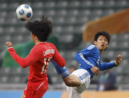 Japan Yuya Osako (R) fights for the ball with South Korea&apos;s Woo Choo-young during their men&apos;s soccer semifinal match at the East Asian Games in Hong Kong December 10, 2009. [China Daily/Agencies] 