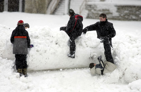 Children play in a pile snow left by a plow in Waukesha, Wisconsin December 9, 2009.[Xinhua/Reuters]