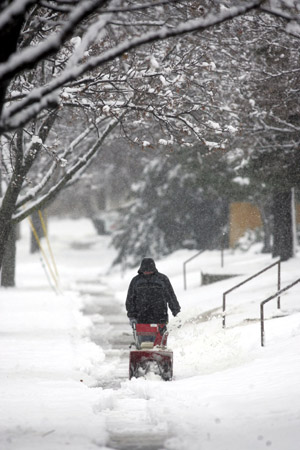 An unidentified man uses a snowblower as he cleans up snow in Waukesha, Wisconsin December 9, 2009.[Xinhua/Reuters]