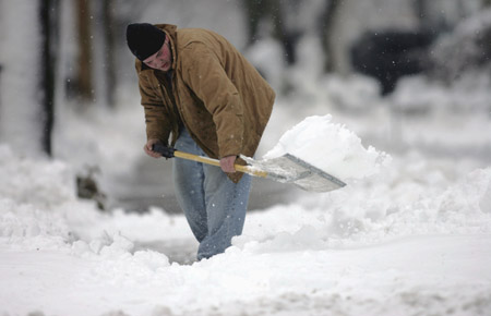 Jared Abt shovels the sidewalk at his residence cleaning up heavy wet snow in Waukesha, Wisconsin December 9, 2009.[Xinhua/Reuters] 