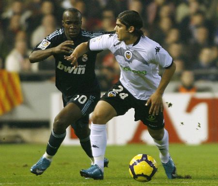 Valencia's Ever Banega (R) and Real Madrid's Lass Diarra fight for the ball during their Spanish first division soccer match at the Mestalla Stadium in Valencia December 12, 2009. [Xinhua/Reuters]