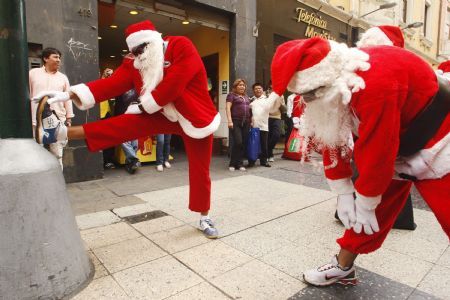 People dressed as Santa Claus stretch before participating in a race through a downtown pedestrian street in Lima December 11, 2009. The event was organized by several downtown stores to promote Christmas shopping.