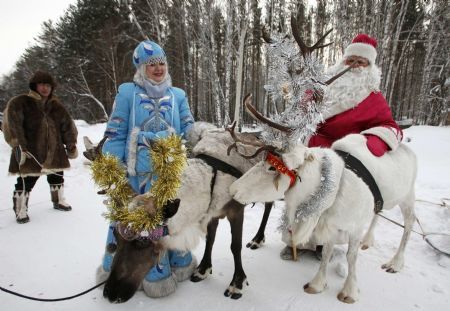 A man dressed as Father Frost, a Russian equivalent to Santa Claus, and a woman dressed as Snow White, Father Frost&apos;s daughter, comfort reindeers in a forest country resort outside the Siberian city of Krasnoyarsk, December 12, 2009.