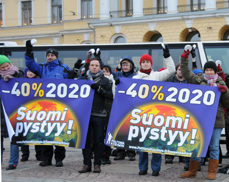 Finnish people hold banners and ring alarms during a protest to demand developed countries&apos; greenhouse gas emission reduction in Helsinki, Dec. 12, 2009.