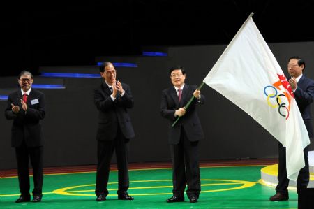 Huang Xingguo(R2), mayor of Tianjin, waves the East Asian Games flag during the closing ceremony of the 2009 East Asian Games in Hong Kong, south China, Dec. 13, 2009. The sixth East Asian Games will be held in Tianjin in 2013. [Song Zhenping/Xinhua]