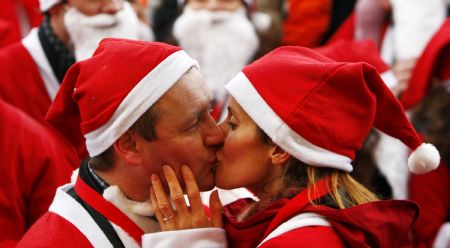 Jenny Allen kisses here fiance Gordon Riley after taking part in The Great Scottish Santa Run in Princes Street gardens in Edinburgh, Scotland December 13, 2009. Gordon, from Sheffield in England, proposed marriage to Jenny just minutes before they both ran in the 1.5 km charity run.[Xinhua/Reuters]