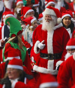 Runners dressed up in Santa Claus outfits jog together during The Great Scottish Santa Run in Princes Street gardens in Edinburgh, Scotland, December 13, 2009.[Xinhua/Reuters]