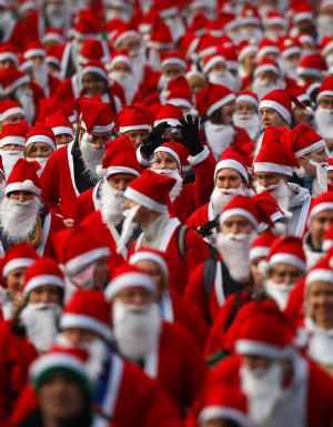 Runners dressed up in Santa Claus outfits jog together during The Great Scottish Santa Run in Princes Street gardens in Edinburgh, Scotland December 13, 2009.[Xinhua/Reuters]