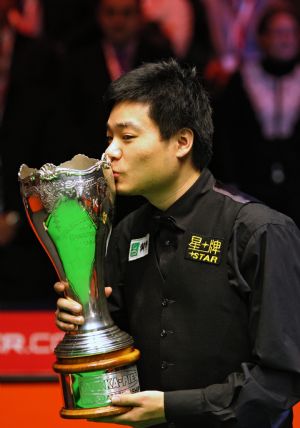 China&apos;s Dingjunhui kisses the trophy after beating Scottish John Higgins in the final of the UK Championship in Telford, Dec. 13, 2009.[Xinhua/AFP]