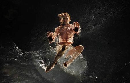 A dancer performs on a watery stage suspended above the audience during the Argentinian show Fuerza Bruta (Brute Force) in New York, Dec. 13, 2009.[Xinhua/Reuters]