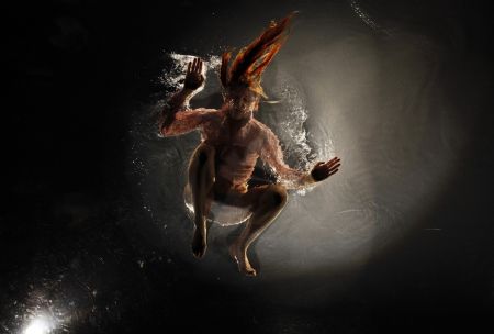 A dancer performs on a watery stage suspended above the audience during the Argentinian show Fuerza Bruta (Brute Force) in New York, Dec. 13, 2009.[Xinhua/Reuters]