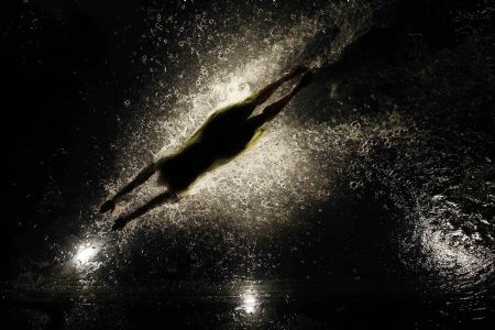 A dancer performs on a watery stage suspended above the audience during the Argentinian show Fuerza Bruta (Brute Force) in New York, Dec. 13, 2009.[Xinhua/Reuters]