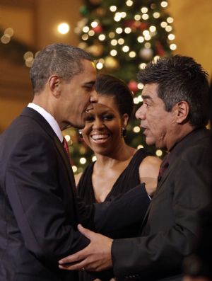 U.S. President Barack Obama (L) and first lady Michelle Obama greet comedian George Lopez during the Christmas in Washington Celebration at the National Building Museum in Washington December 13, 2009.[Xinhua/Reuters]