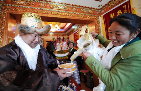 Undated photo shows a Tibetan was presented with wine made from the highland barley on a festive occasion in Lhasa, capital of southwest China's Tibet Autonomous Region. [Xinhua Photo]