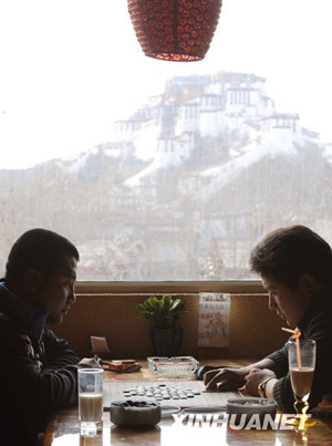 Undated photo shows two Tibetans play chess in a cafe near the Potala Palace in Lhasa, capital of southwest China's Tibet Autonomous Region. (Xinhua Photo)