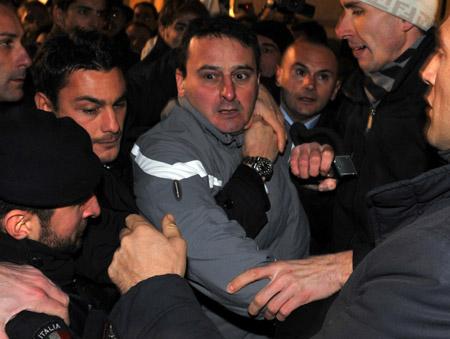 Massimo Tartaglia (C), the man who assaulted Italian Prime Minister Silvio Berlusconi outside a meeting in Milan, is held back before being arrested by Italian police for punching Berlusconi.[Xinhua]