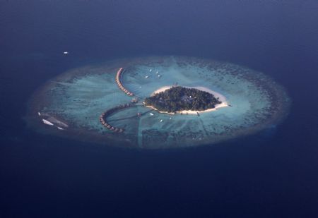 An areal view shows a resort island in the Maldives December 14, 2009. Maldives has a population of some 400,000 islanders, whose livelihood from fishing and tourism is being hit by climate change. Maldives President Mohamed Nasheed said in November that 2 degrees Celsius warming would risk swamping the sand-rimmed coral atolls and islets, dotted with palm trees and mangrove clumps, that form his small country. [Xinhua/Reuters]