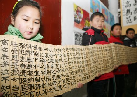 Pupils display their Chinese calligraphy works on Chinese traditional bamboo slips at the Sunny Future Primary School in Xiangfan, central China&apos;s Hubei Province, Dec. 14, 2009. [Gong Bo/Xinhua]