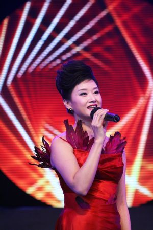 Song Zuying, a well-known Chinese soprano singer, sings during a performance gala marking the 50th anniversary of the founding of the Fujian Provincial Association of Returned Overseas Chinese at the Fujian Provincial Gymnasium in Fuzhou, capital of southeast China&apos;s Fujian Province, Dec. 12, 2009.[Zheng Shuai/Xinhua]